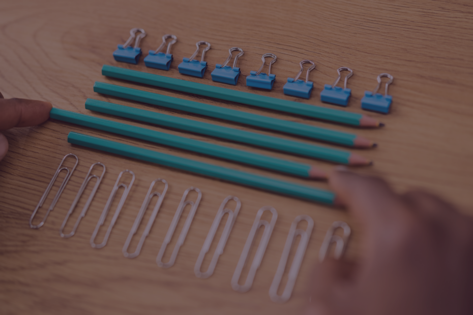 Perfectionism. A person perfectly arranges pencils and paper clips with their hands.